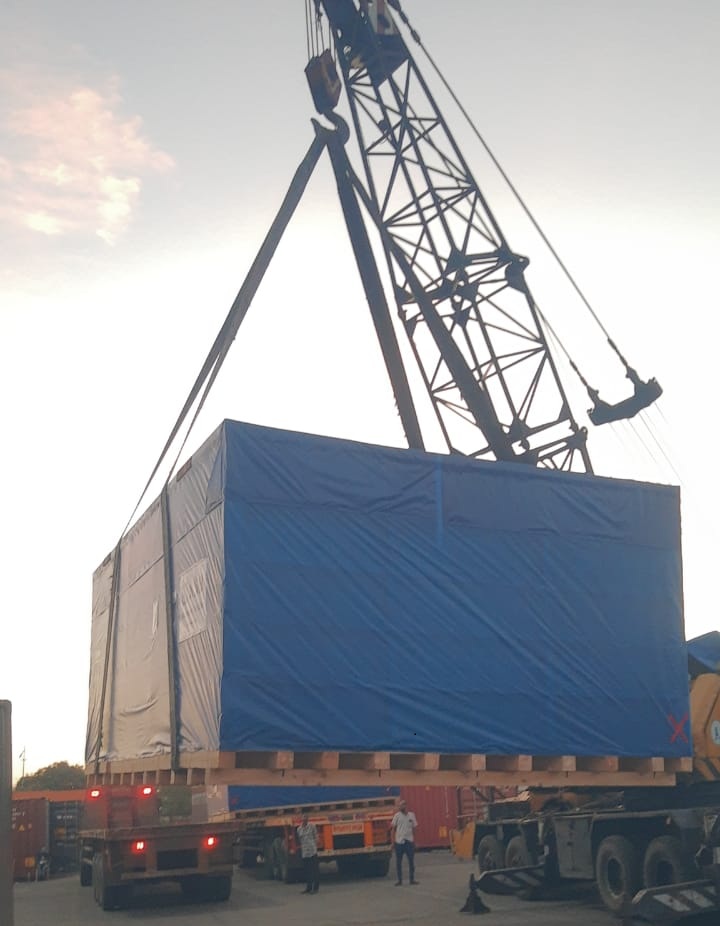 Crane lifting a large crated shipment onto a trailer