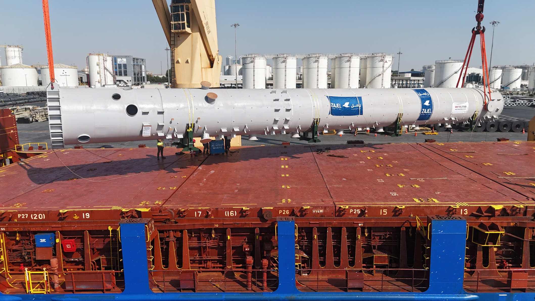 Long cylindrical vessel secured on the deck of a cargo ship