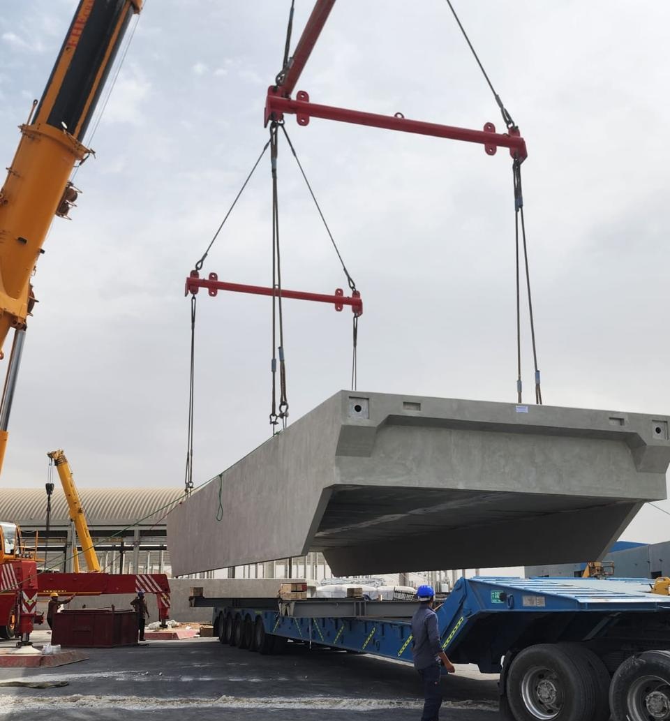 Precast concrete girder being lifted onto a trailer